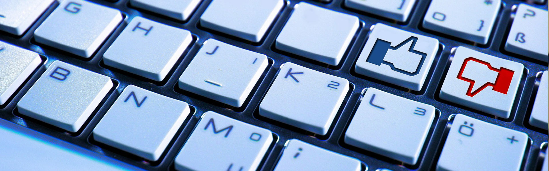 Laptop keyboard shows thumbs-up and thumbs-down icons.