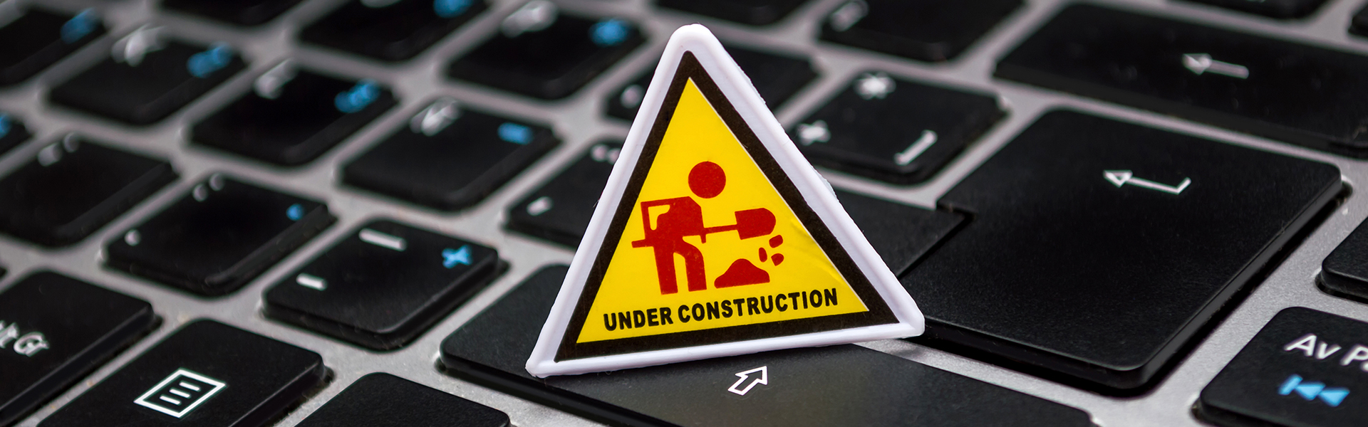 under construction icon displayed on top of a laptop keyboard.